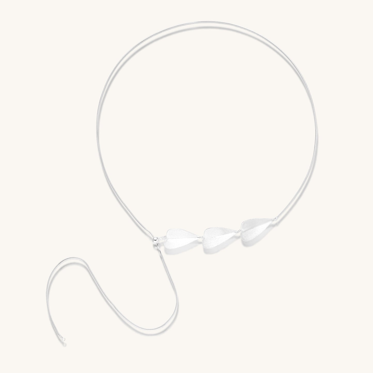 Delicate sterling silver necklace with brushed leaf pendants distributed along a fine chain on white background.