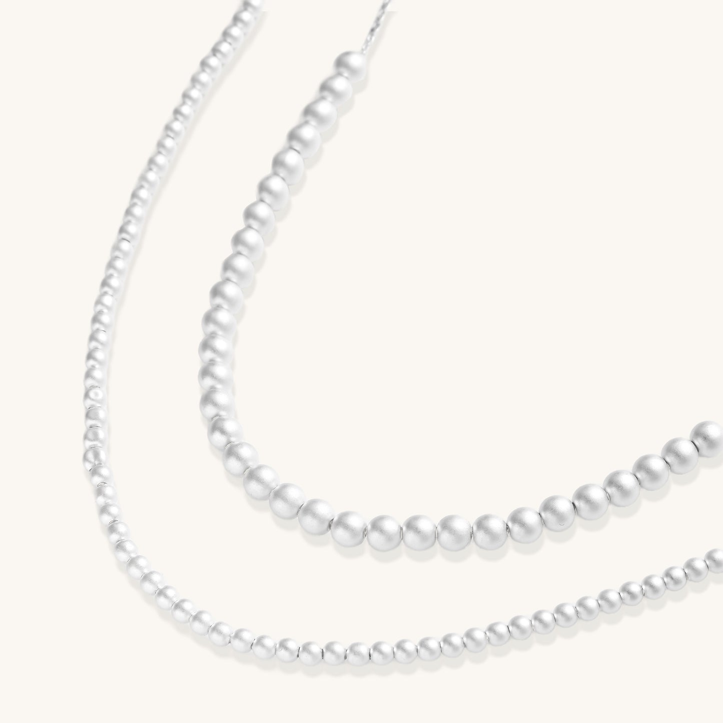 Sterling silver necklace with graduated pearl beads and delicate chain sections featuring a toggle clasp closure.