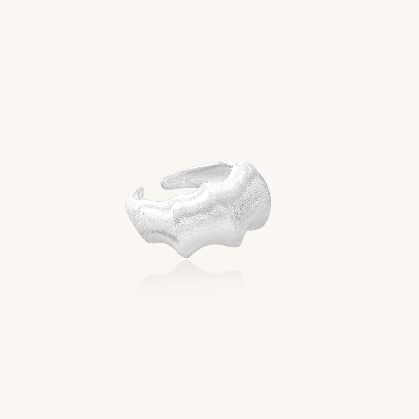 Chunky sterling silver ring with organic flowing design and brushed matte finish on neutral background