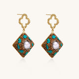 Gold quatrefoil stud earrings with ornate square pendants featuring turquoise stones and freshwater pearls