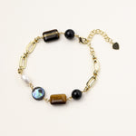 Gold-plated chain bracelet featuring tiger's eye, obsidian, freshwater pearls and abalone shell on white background