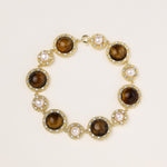 Ornate gold-plated bracelet with alternating brown tiger's eye stones and white freshwater pearls in crystal-accented settings