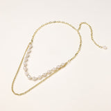 Layered gold chain necklace with irregular freshwater pearls on cream background, showing adjustable dual-strand design.