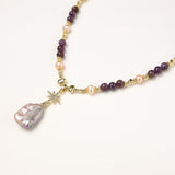 Gold-plated necklace with purple amethyst beads, pink pearls, and iridescent baroque pearl pendant beneath crystal star charm