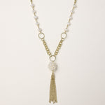 Layered gold-plated necklace with freshwater pearls, central pearl cluster, and chain tassel on cream background.