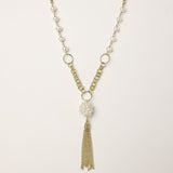 Layered gold-plated necklace with freshwater pearls, central pearl cluster, and chain tassel on cream background.