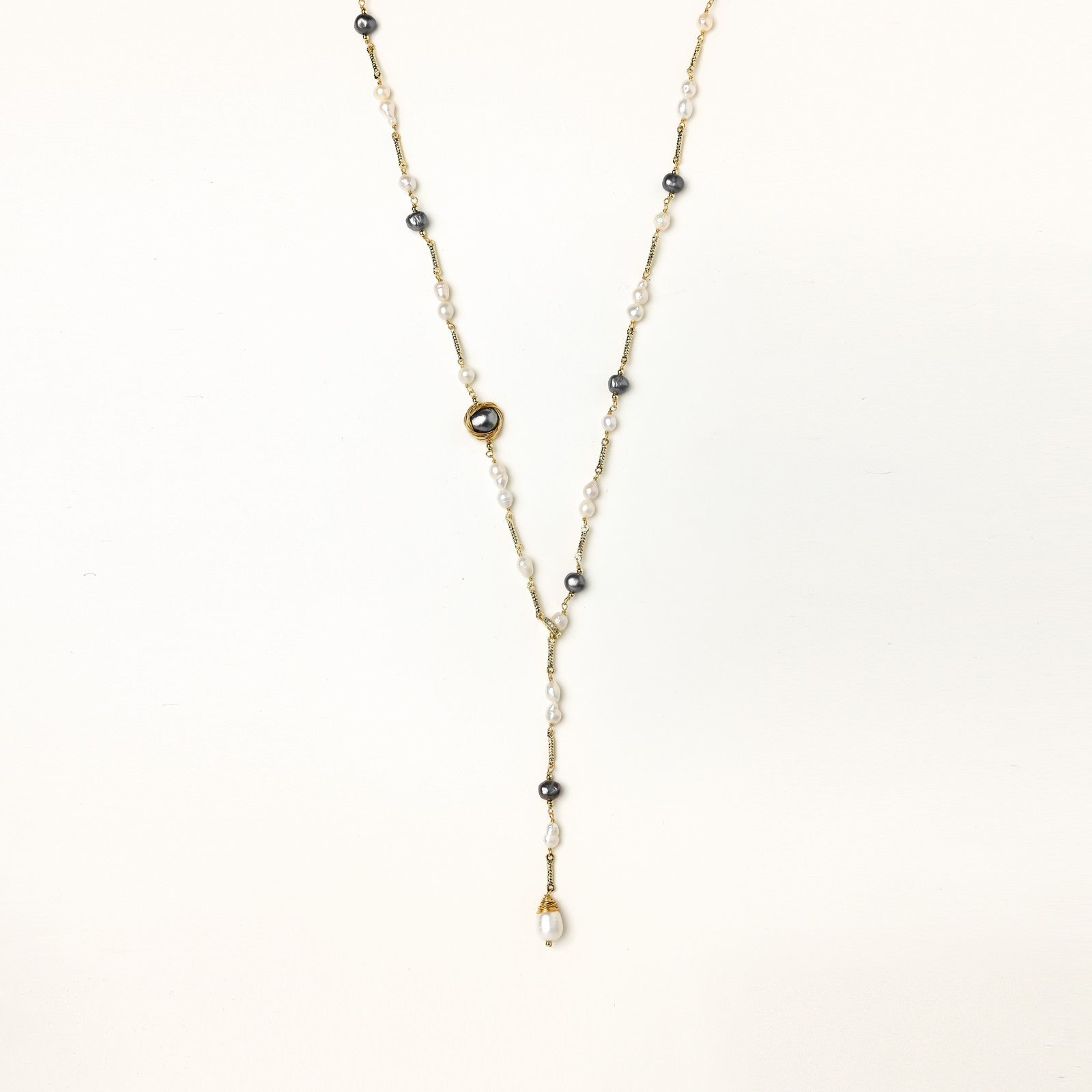 Long gold-plated necklace with alternating white and gray freshwater pearls spaced along delicate chain segments