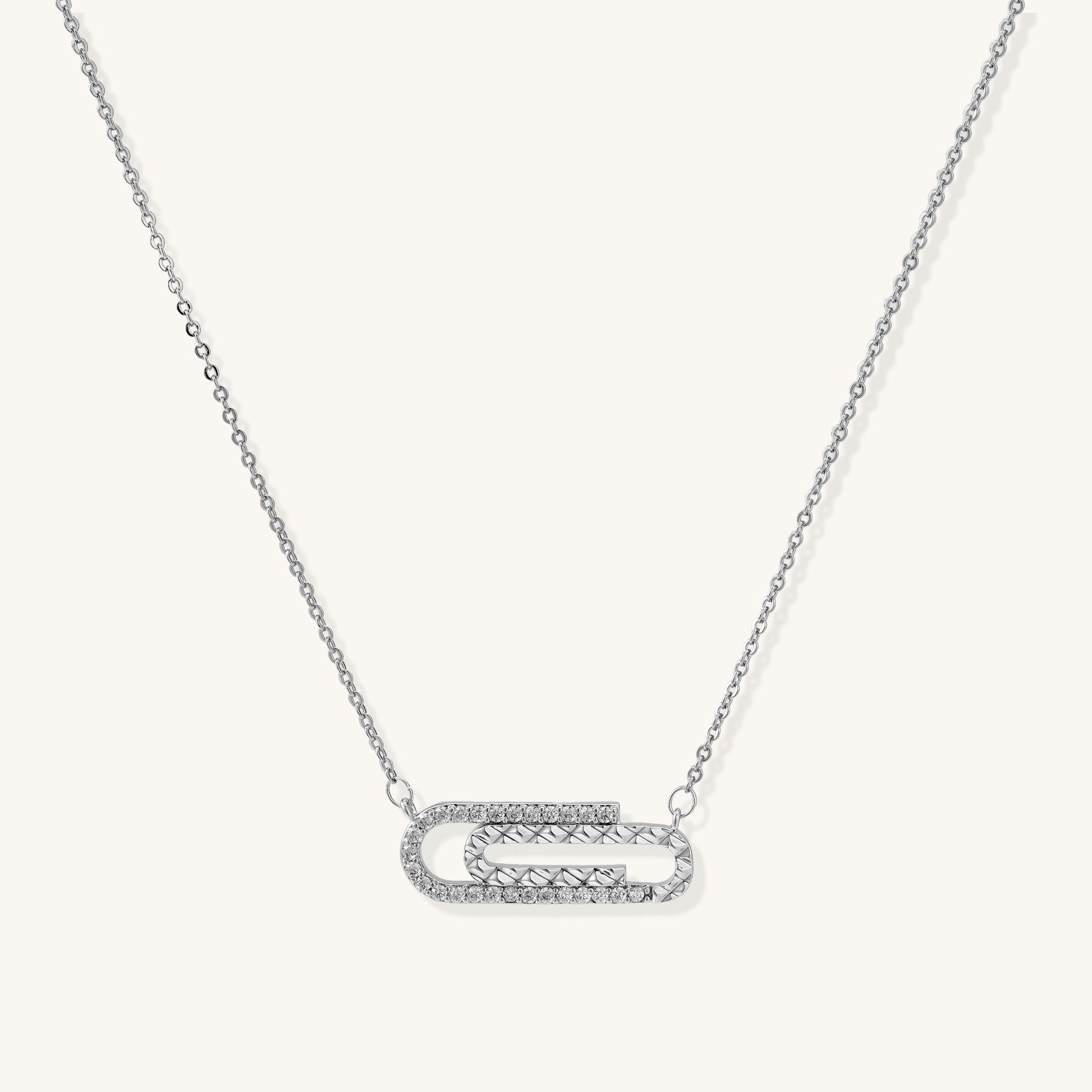 Delicate 14K gold plated chain necklace with crystal-accented carabiner-style pendant on white background