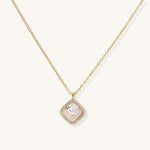 Gold-plated necklace with cushion-shaped pendant featuring a freshwater pearl surrounded by crystal halo on white background.