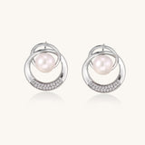 Gold-plated brass stud earrings with swirled circular design holding white freshwater pearls and small crystals