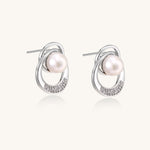 Gold-plated brass stud earrings with swirled circular design holding white freshwater pearls and small crystals