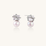 Gold-plated stud earrings with square crystal tops wrapped in twisted wire and freshwater pearl drops on white background
