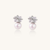 Gold-plated stud earrings with square crystal tops wrapped in twisted wire and freshwater pearl drops on white background
