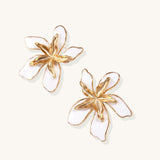 Large floral stud earrings with gold-plated brass petals and white enamel centers on neutral background