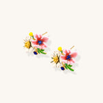 Detailed view of gold-plated brass stud earrings featuring multicolor enamel flowers with white, pink, and blue petals