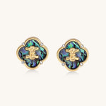 Gold-plated quatrefoil stud earrings featuring iridescent abalone shell centers with decorative motifs and crystal accents