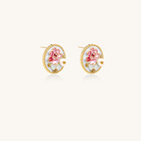 Round gold-plated stud earrings featuring pink enamel roses with freshwater pearl accents on white background.