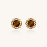 Ornate gold-plated brass stud earrings featuring round tiger's eye stones surrounded by sparkling zirconia in floral design
