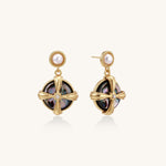 Gold-plated drop earrings with cross design framing iridescent abalone shell and pearl studs on neutral background.