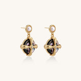 Gold-plated drop earrings with cross design framing iridescent abalone shell and pearl studs on neutral background.
