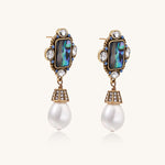 Gold-plated brass drop earrings featuring iridescent abalone shell centers, crystal accents, and white pearl drops.