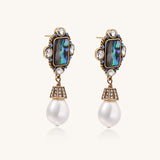 Gold-plated brass drop earrings featuring iridescent abalone shell centers, crystal accents, and white pearl drops.