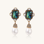 Gold-plated brass drop earrings featuring iridescent abalone shell centers, crystal accents, and white pearl drops.