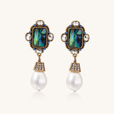 Gold-plated brass drop earrings featuring iridescent abalone shell centers, crystal accents, and white pearl drops.