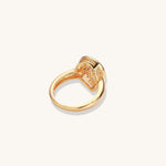 Gold-plated heart ring with turquoise enamel scrollwork and cubic zirconia stones on white background