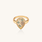 Gold-plated heart ring with turquoise enamel scrollwork and cubic zirconia stones on white background