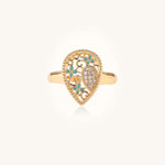 Gold-plated heart ring with turquoise enamel scrollwork and cubic zirconia stones on white background