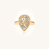 Gold-plated heart ring with turquoise enamel scrollwork and cubic zirconia stones on white background