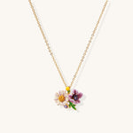 Delicate 18K gold plated necklace featuring colorful enamel flowers in pink and white with green leaves on chain