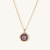 Gold-plated necklace with purple enamel pendant featuring pink floral design on white background