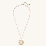 Gold-plated pendant necklace with circular orbital design, iridescent mother-of-pearl center and green zirconia accents