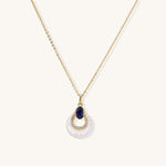 Layered pendant necklace with deep blue lapis lazuli stone, crystals, and white mother of pearl on 18k gold plated chain