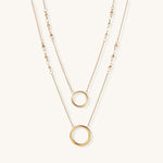 Gold-plated layered necklace set with two circular pendants featuring white centers on delicate chains.