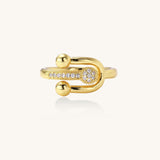 Modern gold-plated adjustable ring with safety pin design and sparkling cubic zirconia accents on white background