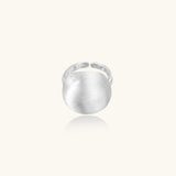 Minimalist brushed sterling silver dome ring with adjustable band on white background, front view.