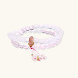 Double-wrap lavender beaded bracelet with rose quartz, pearls, gold vermeil charm and pink tassel on white background.