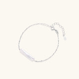 Minimalist bracelet with iridescent baroque pearl on rhodium-plated sterling silver chain against cream background