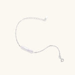 Minimalist bracelet with iridescent baroque pearl on rhodium-plated sterling silver chain against cream background