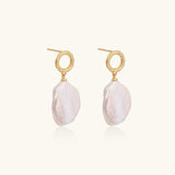 18K gold vermeil twisted circle studs with organic white baroque pearl drops on cream background