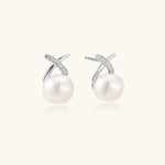 Rhodium-plated silver stud earrings with sparkling X design above lustrous round freshwater pearls on white background.