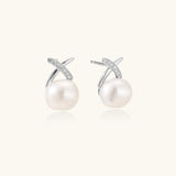 Rhodium-plated silver stud earrings with sparkling X design above lustrous round freshwater pearls on white background.