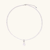 Dainty necklace with lavender crystal beads, freshwater pearls, geometric pendant, and large pearl drop on white background.