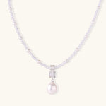 Dainty necklace with lavender crystal beads, freshwater pearls, geometric pendant, and large pearl drop on white background.