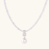 Dainty necklace with lavender crystal beads, freshwater pearls, geometric pendant, and large pearl drop on white background.