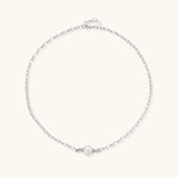 Dainty rhodium-plated silver chain necklace with centered 10mm freshwater pearl and crystal accents on cream background