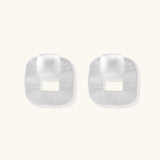 Pair of geometric sterling silver earrings with frosted square frames and glossy rounded studs on white background